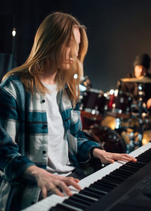 Girl playing synthesizer in a recording studio.